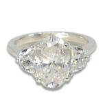 Three Stone Oval Moissanite 4.43ctw. Ring with Half Moon Accents