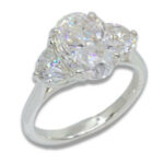 Three Stone Oval Moissanite 4.43ctw. Ring with Half Moon Accents
